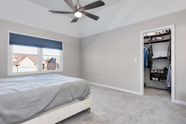 carpeted bedroom with a walk in closet, a closet, ceiling fan, and lofted ceiling