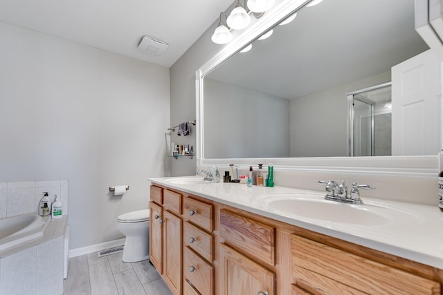 full bathroom featuring hardwood / wood-style flooring, vanity, toilet, and independent shower and bath