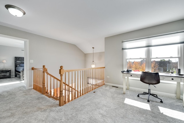 carpeted home office featuring vaulted ceiling