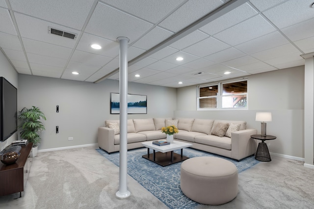 carpeted living room featuring a drop ceiling