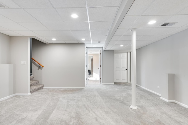 basement featuring light carpet and a paneled ceiling