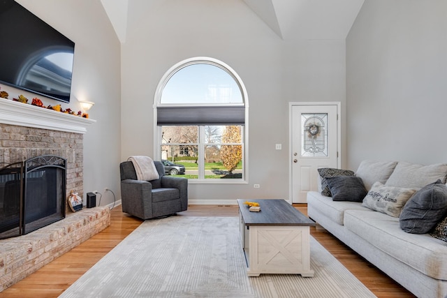 living room featuring hardwood / wood-style floors, a fireplace, and high vaulted ceiling