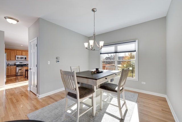 dining area featuring a chandelier and light hardwood / wood-style floors