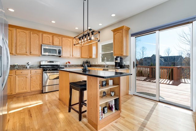 kitchen with light wood-type flooring, light brown cabinetry, a center island, and stainless steel appliances