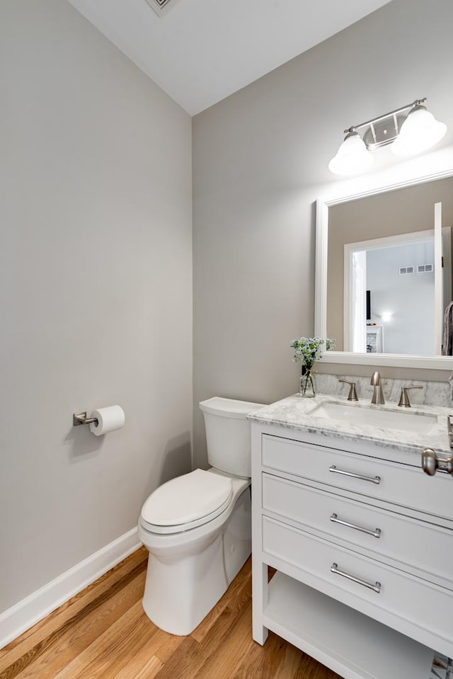 bathroom featuring toilet, vanity, and hardwood / wood-style flooring