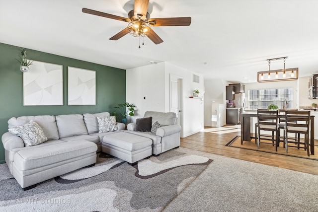 living room with ceiling fan and light hardwood / wood-style floors