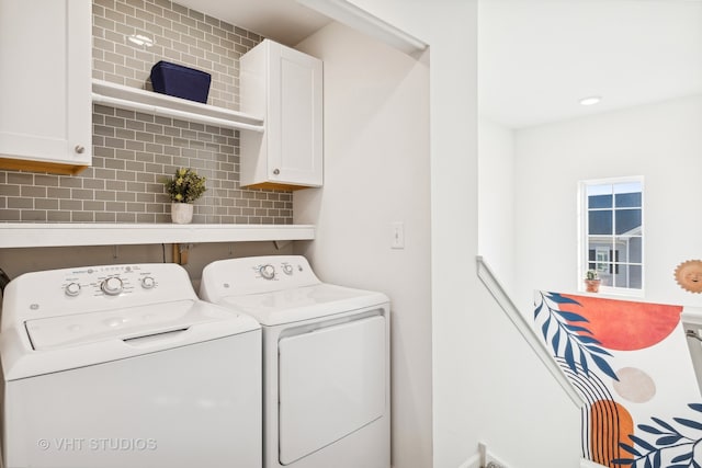 laundry area featuring washer and dryer and cabinets