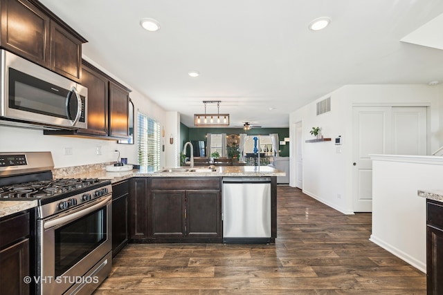 kitchen with ceiling fan, sink, stainless steel appliances, dark hardwood / wood-style floors, and kitchen peninsula