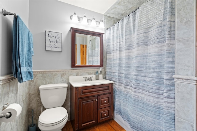 bathroom with a shower with curtain, toilet, vanity, tile walls, and hardwood / wood-style flooring