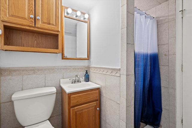 bathroom with vanity, tile walls, and toilet