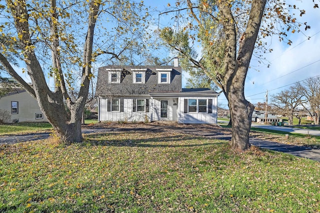 cape cod-style house featuring a front lawn