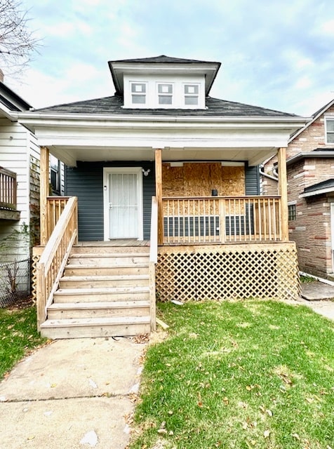 bungalow-style house with a porch and a front lawn