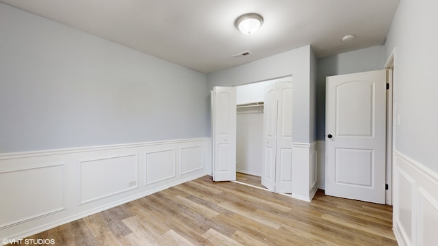 unfurnished bedroom featuring light hardwood / wood-style floors and a closet