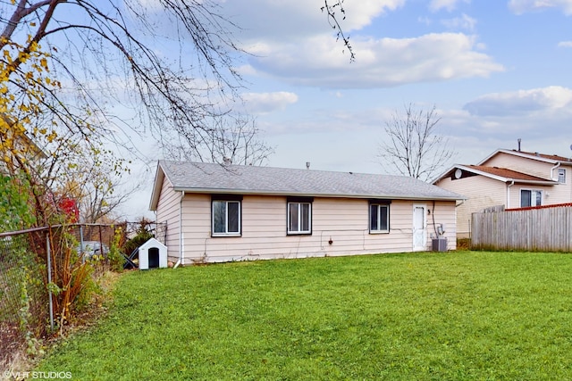 rear view of property featuring a yard and cooling unit