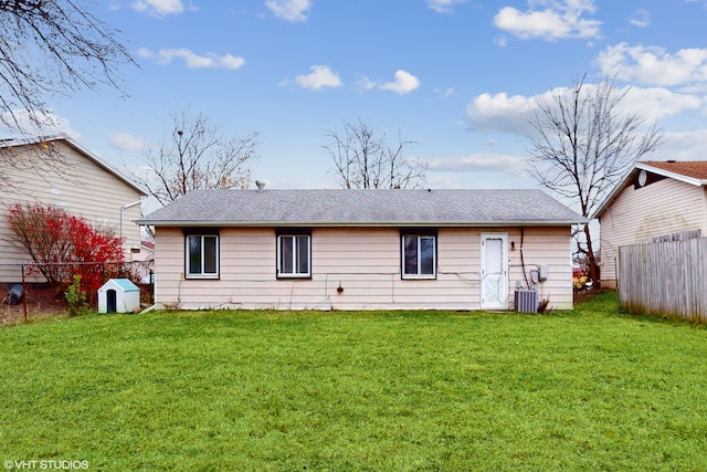 back of property featuring central AC and a yard