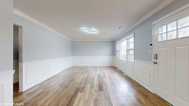 foyer featuring light hardwood / wood-style floors and crown molding