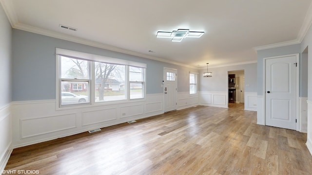 entrance foyer featuring a wealth of natural light, light hardwood / wood-style floors, and ornamental molding