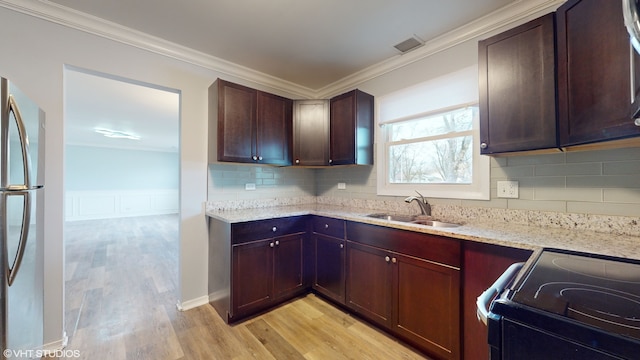 kitchen featuring light stone countertops, sink, stainless steel appliances, light hardwood / wood-style flooring, and ornamental molding