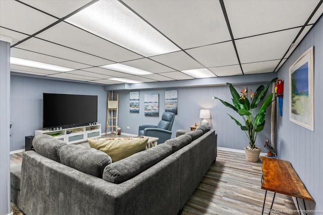 living room with a paneled ceiling, wooden walls, and hardwood / wood-style flooring