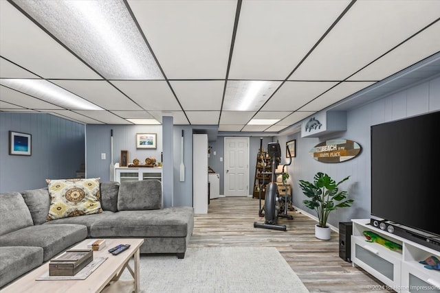 living room featuring light hardwood / wood-style flooring and a drop ceiling