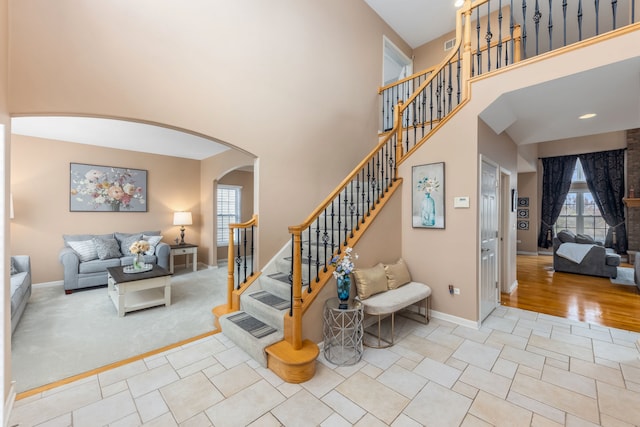 stairway with a high ceiling and hardwood / wood-style flooring