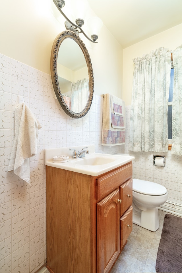 bathroom with vanity, tile walls, and toilet