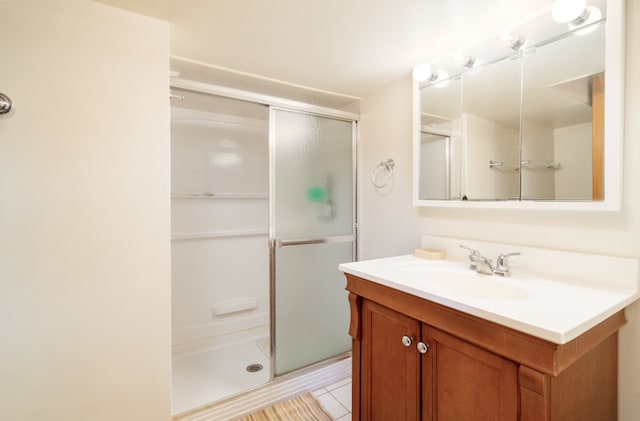 bathroom featuring tile patterned flooring, vanity, and a shower with shower door