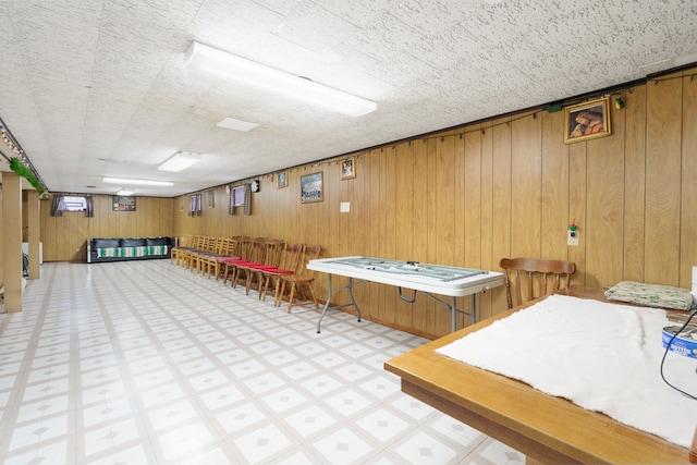 playroom featuring wooden walls and a textured ceiling