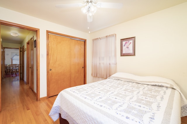 bedroom with ceiling fan, light wood-type flooring, and a closet