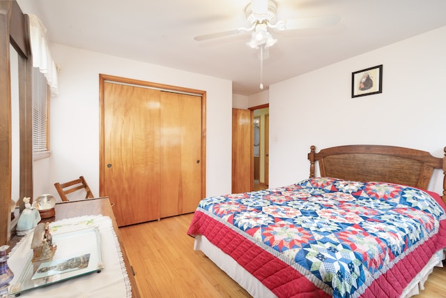 bedroom with ceiling fan, light hardwood / wood-style floors, and a closet