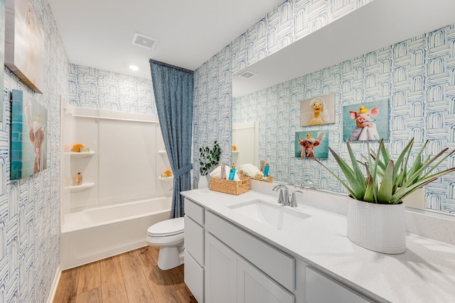 full bathroom featuring hardwood / wood-style flooring, vanity, toilet, and shower / tub combo