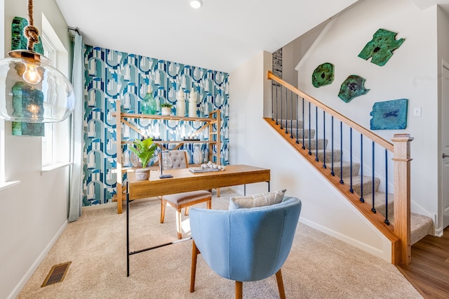 carpeted office space featuring visible vents and baseboards