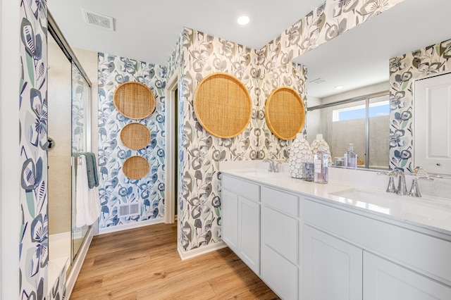 full bathroom with wallpapered walls, a sink, and visible vents