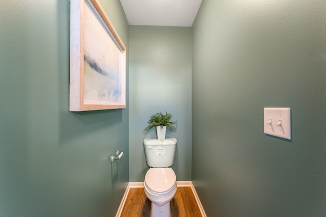 bathroom featuring toilet, wood finished floors, and baseboards
