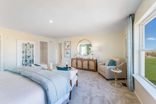 bedroom featuring french doors, light colored carpet, multiple windows, and visible vents