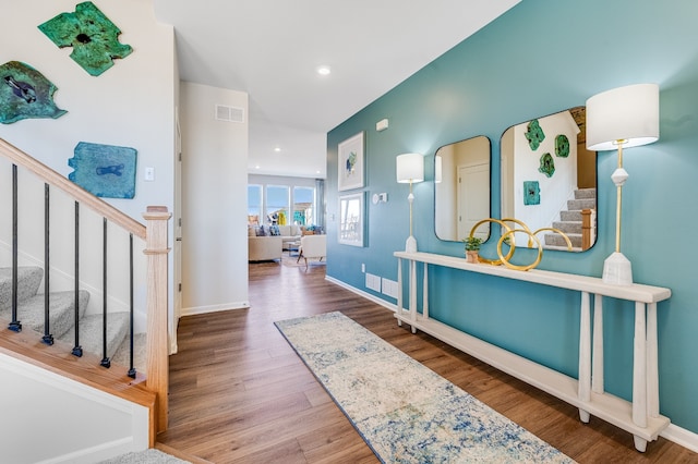 foyer entrance with visible vents, baseboards, recessed lighting, wood finished floors, and stairs
