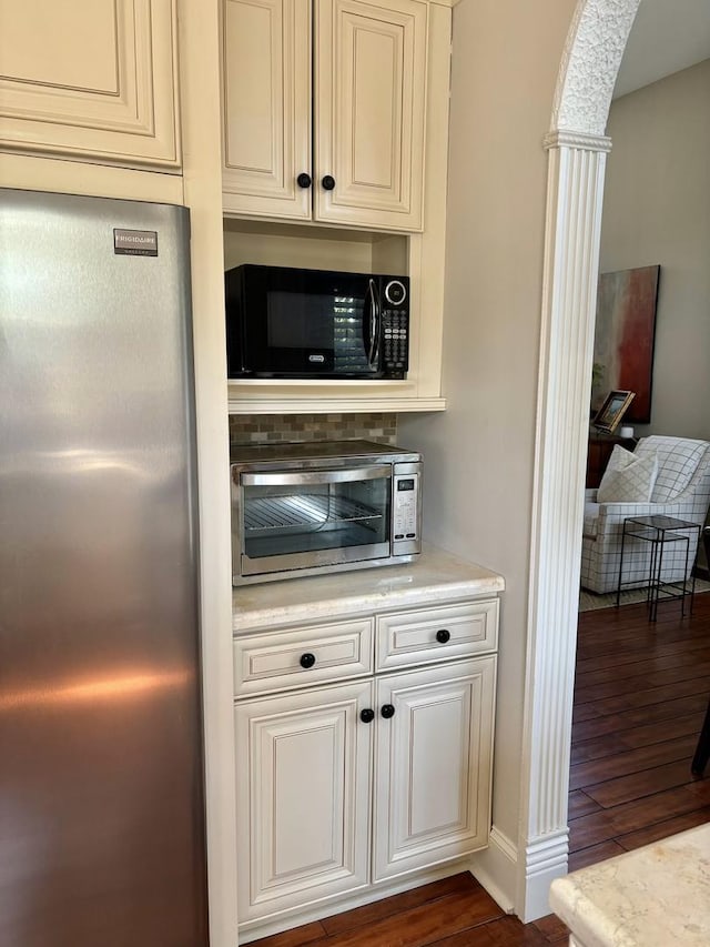 kitchen with dark hardwood / wood-style flooring and stainless steel refrigerator