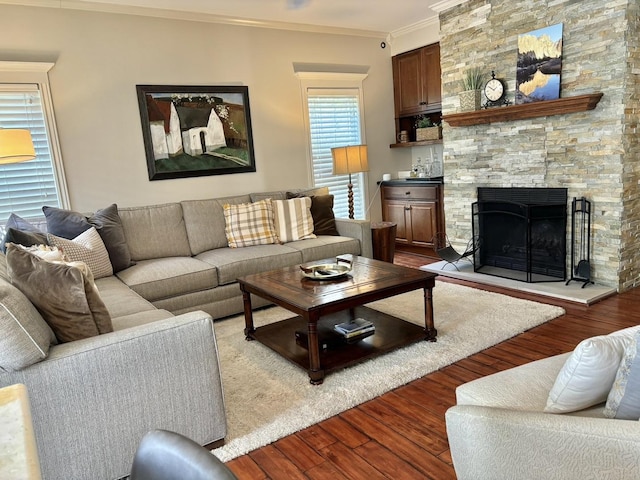 living room featuring a stone fireplace, crown molding, and light hardwood / wood-style floors