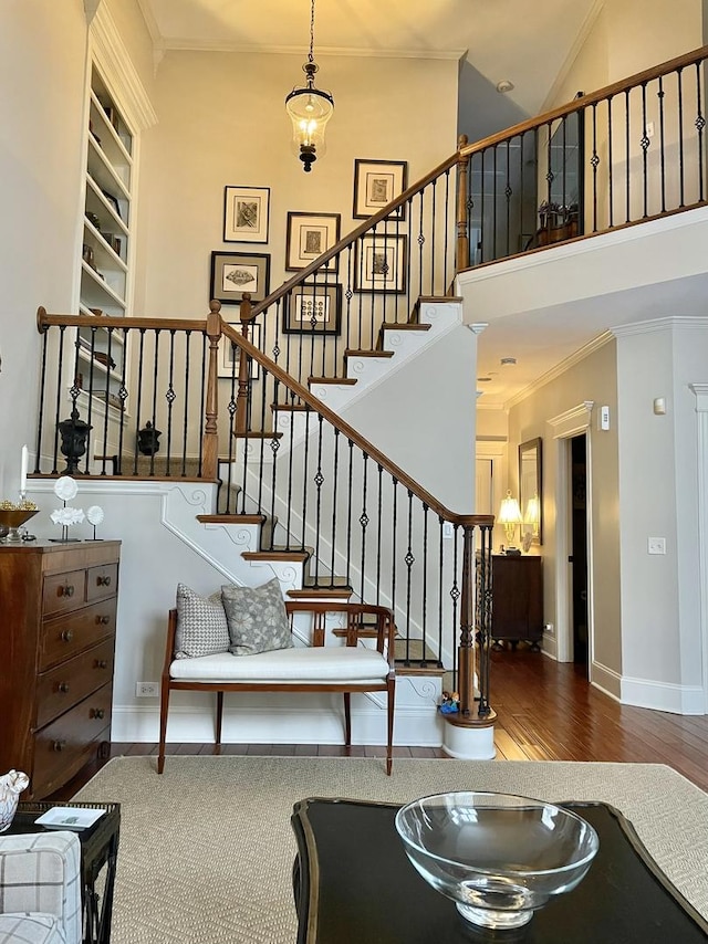 stairway with hardwood / wood-style floors and ornamental molding