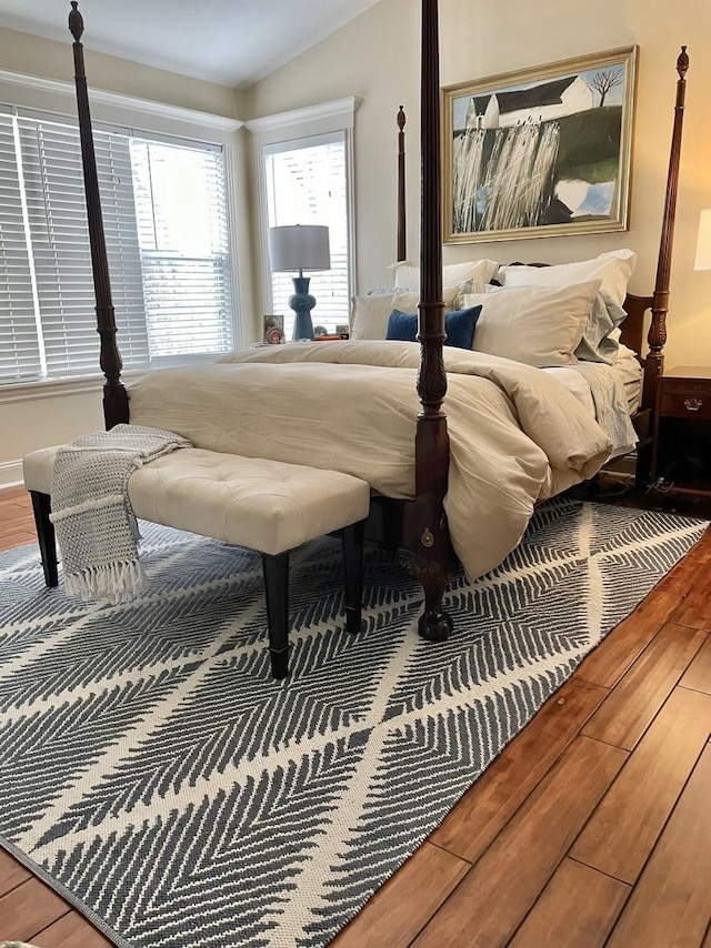 bedroom featuring wood-type flooring and vaulted ceiling