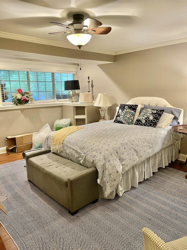 bedroom with hardwood / wood-style floors, ceiling fan, and crown molding