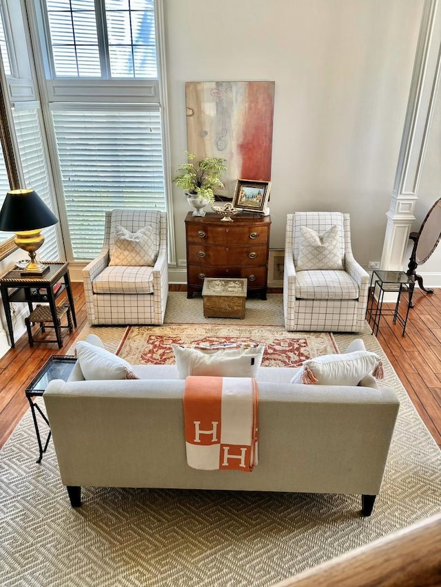 living room featuring hardwood / wood-style floors, ornate columns, and a healthy amount of sunlight