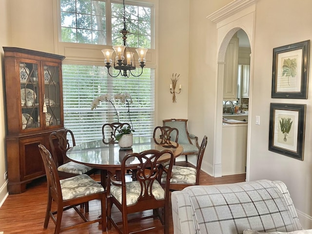 dining room with a healthy amount of sunlight, hardwood / wood-style floors, a chandelier, and sink