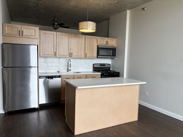 kitchen with appliances with stainless steel finishes, light brown cabinetry, a sink, and light countertops