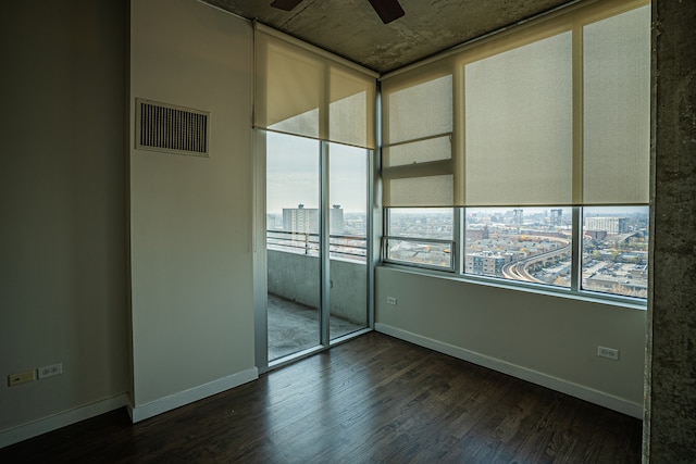 unfurnished room with a wealth of natural light, ceiling fan, and dark hardwood / wood-style floors