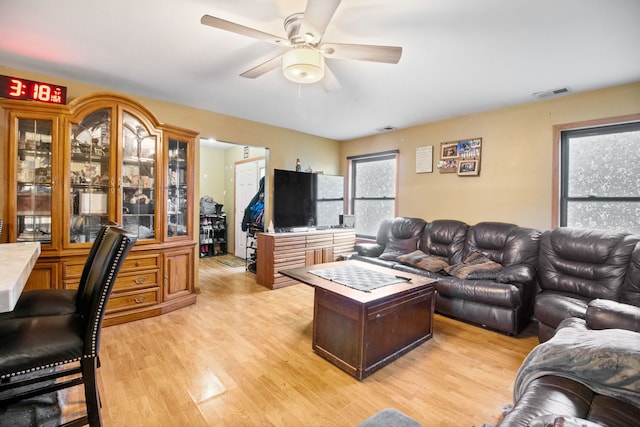 living room featuring ceiling fan and light hardwood / wood-style floors