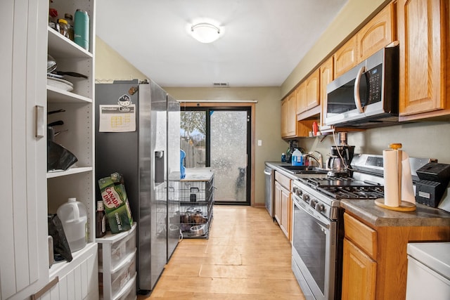 kitchen featuring light hardwood / wood-style floors, sink, and appliances with stainless steel finishes