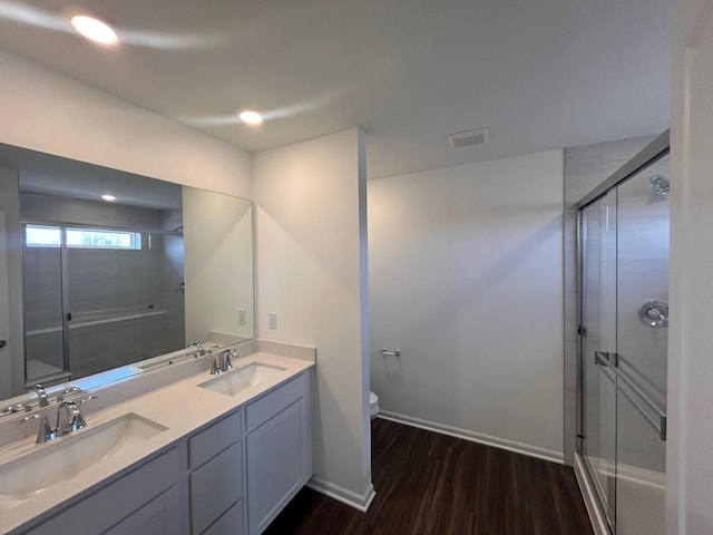 full bath with a stall shower, wood finished floors, and a sink
