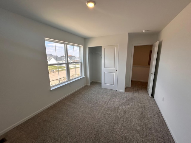 unfurnished bedroom featuring a closet, carpet flooring, and baseboards
