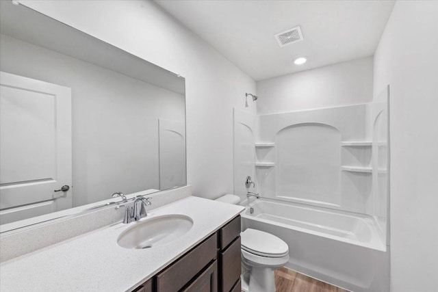 full bathroom featuring hardwood / wood-style floors, vanity, shower / bathtub combination, and toilet